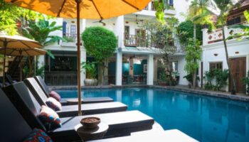 Rambutan Resort Siem Reap swimming pool view. Gay hotel with sun loungers and umbrellas. Top wellness destination for gay men travelers.