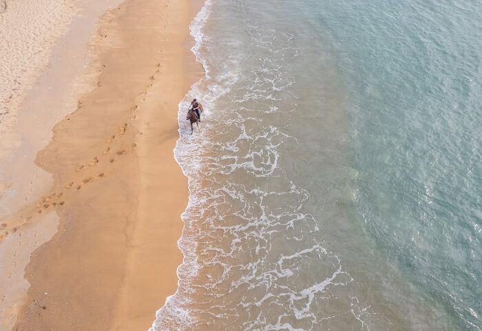 Melia Phuket Mai Khao: Aerial view of a man riding a horse on the beach at a gay-friendly wellness hotel in Phuket, Thailand. Mai Khao beach.