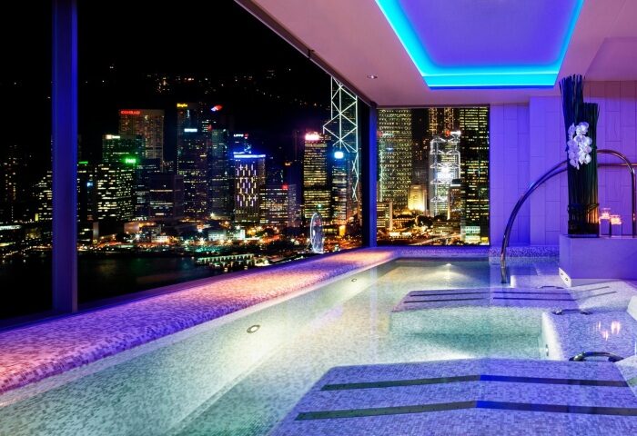 W Hong Kong hotel's pool with a stunning night view of Hong Kong Harbour. Top gay honeymoon hotel. Luxury travel for gay men.