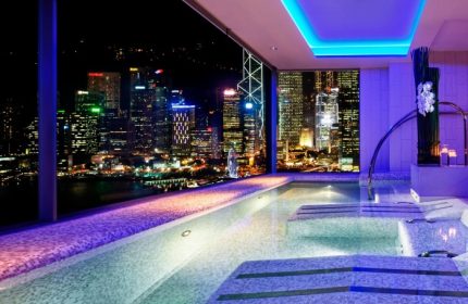 W Hong Kong hotel's pool with a stunning night view of Hong Kong Harbour. Top gay honeymoon hotel. Luxury travel for gay men.