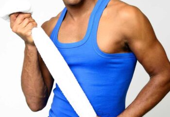 Touch2Massage by Arnie: Gay massage spa model in blue tank top and yellow shorts holding a towel. Gay travel advice.