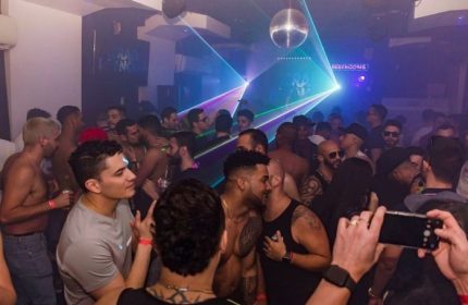 Inside True Colors Bar, New York. Gay men socialize under disco ball and laser lights. Nightlife, travel advice for gay men.
