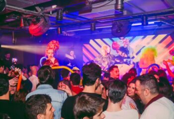 Trump's Lisbon gay bar scene. Drag queen performing on stage at a crowded gay club. Nightlife in Lisbon for gay men travel advice.