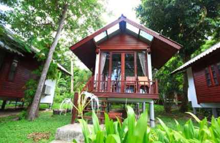 Tubtim Resort Koh Samet beachfront hotel. Wooden bungalow with balcony, steps, and tropical foliage. A popular gay-friendly destination.