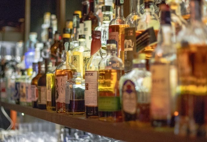 Tuk Tuk Bar Budapest: Bar shelf filled with liquor bottles. A popular gay bar in Budapest, Hungary, offering a wide selection of drinks.