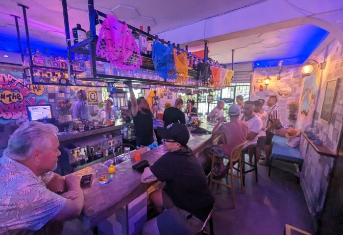 Tunnel Gay Bar in Puerto Vallarta. Patrons at the bar, drinking and socializing. Colorful decor, lively atmosphere. Gay travel.