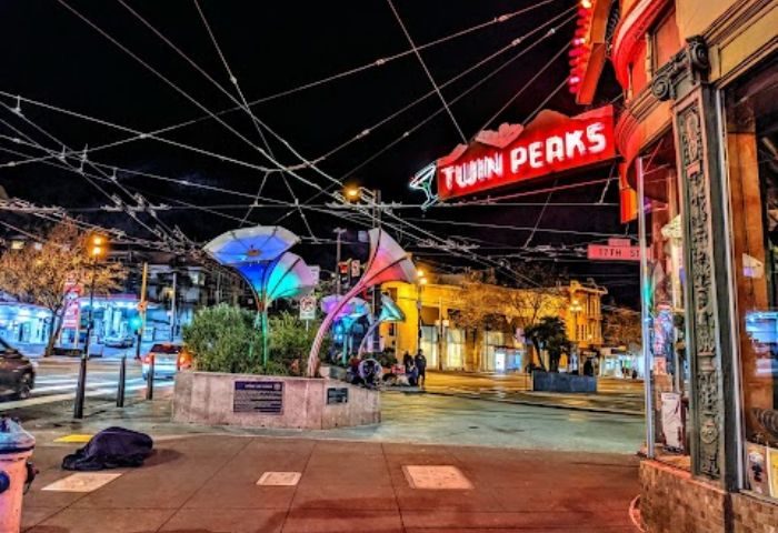 Twin Peaks Tavern in San Francisco at night. A landmark gay bar in the Castro District. Neon sign, street scene, and colorful lights.