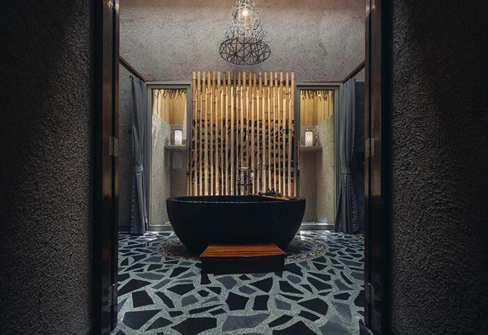 Keemala Phuket luxury gay hotel bathroom. Unique design with a black tub, bamboo screen, and mosaic floor. Instagram-worthy travel.