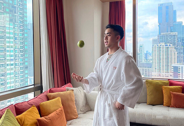 Gay traveler in VIE Hotel Bangkok, a top gay hotel in Bangkok near Silom. Man in robe with city view, near gay bars.