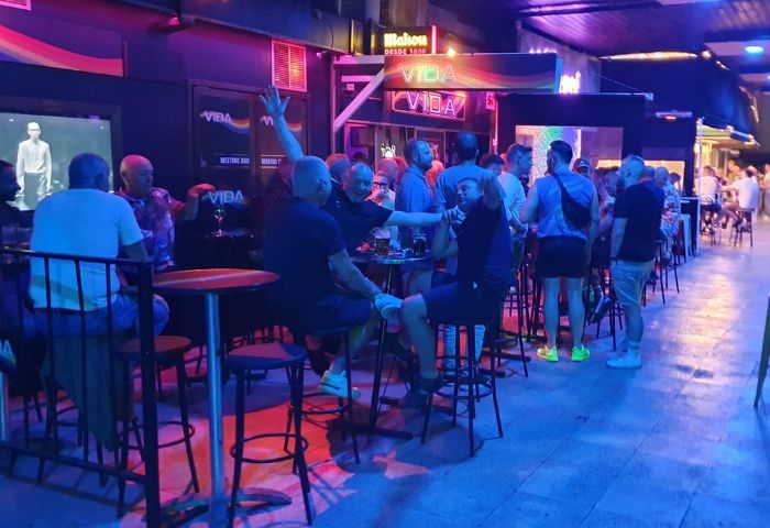 Vida Bar, a popular gay bar in Torremolinos, Spain. Men are socializing and enjoying drinks in a lively, vibrant atmosphere.