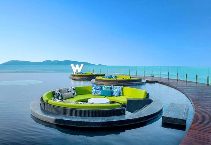 W Koh Samui gay hotel: Round seating areas float in a pool overlooking the ocean. Luxury travel destination for gay men. Thailand resort.
