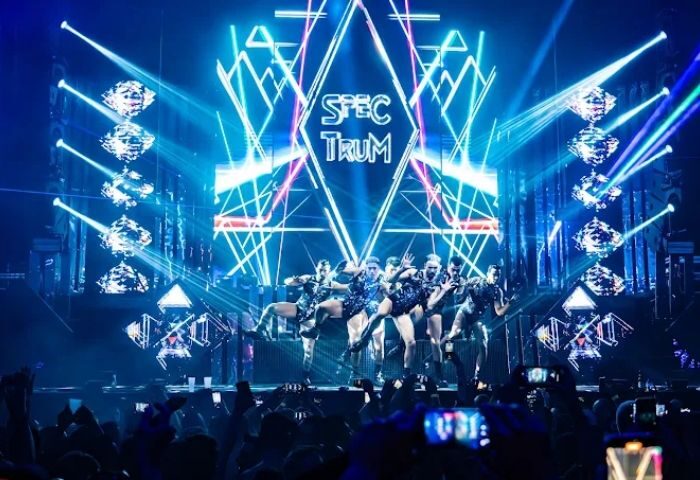 WE Party Madrid gay bar stage show. Dancers perform on stage with bright lights and a large crowd. Gay travel advice for Madrid nightlife.