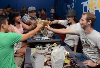 Wang Chung's Karaoke Bar in Honolulu: Friends toasting drinks. Gay travel advice for bars, drinks, and nightlife in Honolulu, Hawaii.