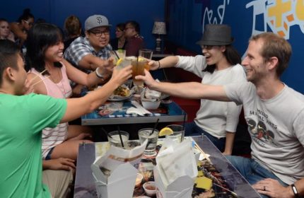 Wang Chung's Karaoke Bar in Honolulu: Friends toasting drinks. Gay travel advice for bars, drinks, and nightlife in Honolulu, Hawaii.