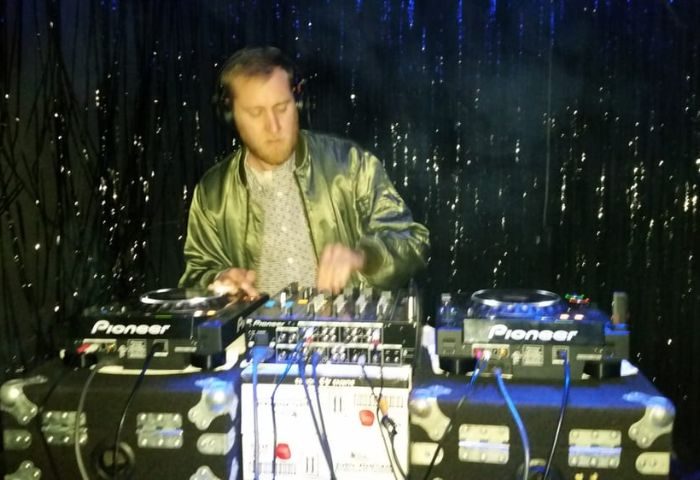 DJ at Wangs Gay Bar in Chicago. Man mixing music on Pioneer equipment. Nightlife scene, gay travel advice.