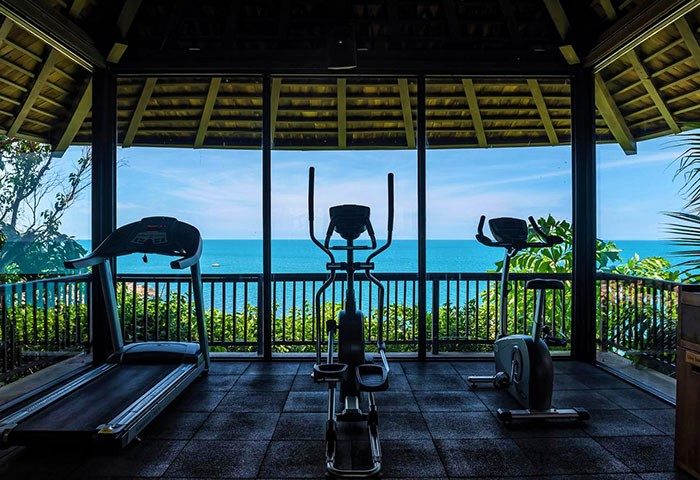 Silavadee Pool Spa Resort's gym in Koh Samui. Wellness retreat for gay travelers with ocean view, treadmill, elliptical, and exercise bike.