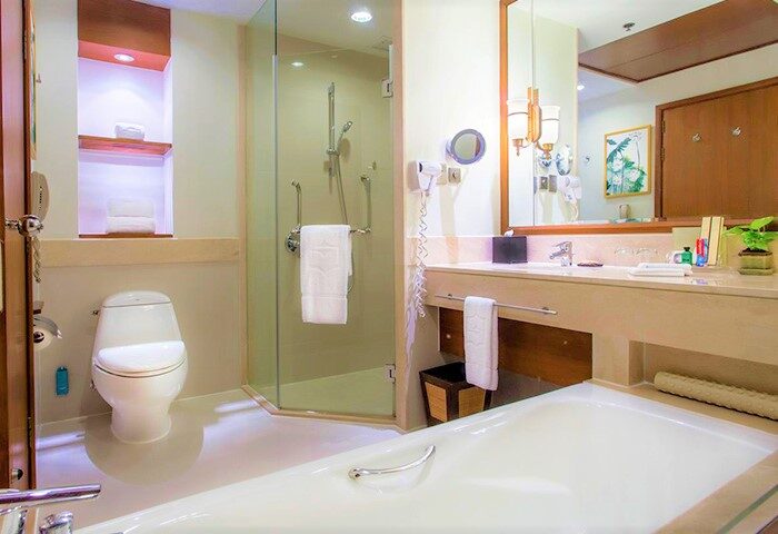 Shangri-La Chiang Mai luxury hotel bathroom. Thai design with shower, toilet, and bathtub. Gay travel wellness destination.