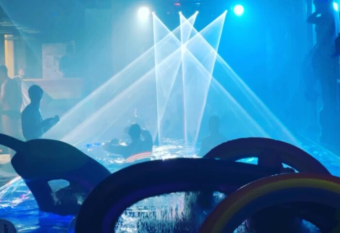 Wet on Wellington, Melbourne: Gay men enjoy a pool party with blue lights and rainbow inflatables. Nightlife travel advice.