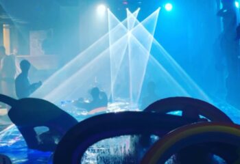 Wet on Wellington, Melbourne: Gay men enjoy a pool party with blue lights and rainbow inflatables. Nightlife travel advice.