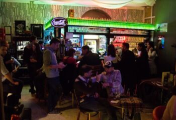 Why Not Cafe and Bar, Budapest. Gay bar scene with patrons at the bar and tables. Budapest travel advice for gay men.