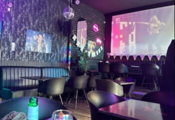 Why Not Cafe and Bar, Budapest interior. Stylish seating, disco ball, and a large screen. A popular gay bar destination in Hungary.