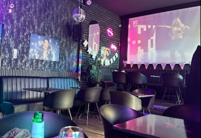 Why Not Cafe and Bar, Budapest interior. Stylish seating, disco ball, and a large screen. A popular gay bar destination in Hungary.
