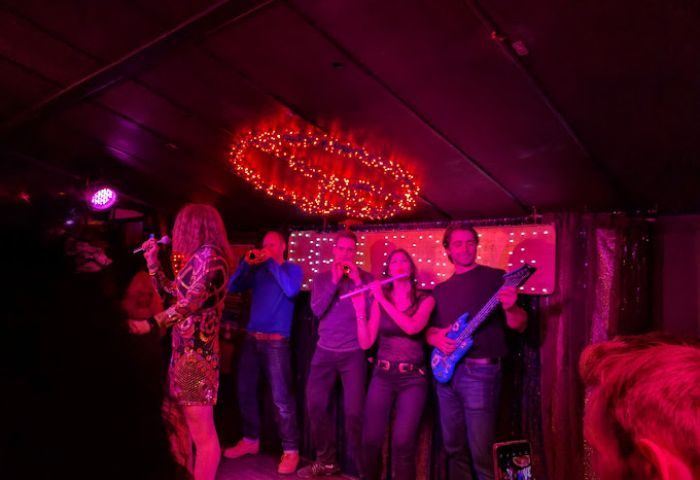 Live music at Woody's and Sailor Bar, a gay bar in Toronto. Band performing under red lights. Gay travel advice, nightlife.