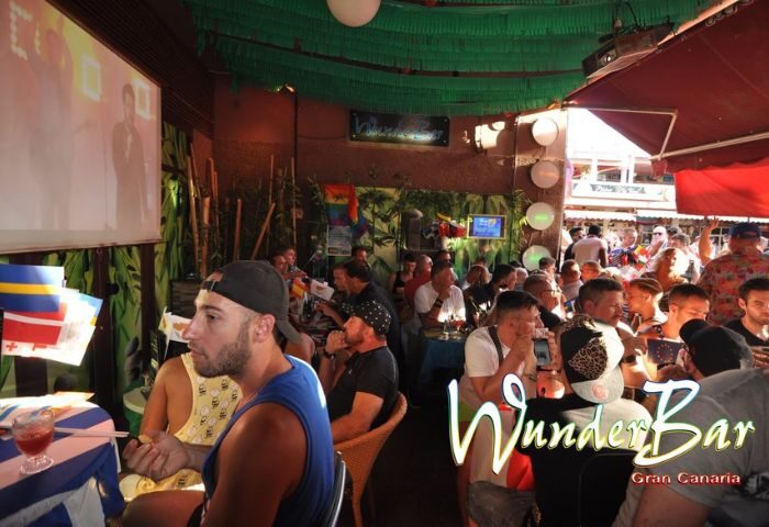 WunderBar Gay Bar in Gran Canaria: A lively, crowded scene at this popular gay bar. People are seated at tables, enjoying drinks.