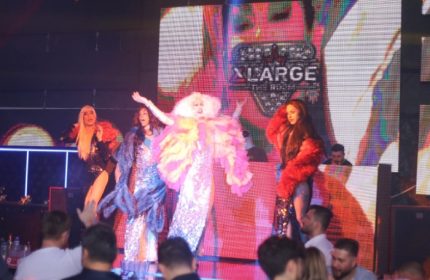 Drag queens perform at XLarge Club Istanbul, a popular gay nightlife spot. The stage is lit with colorful lights, and the audience enjoys the show.
