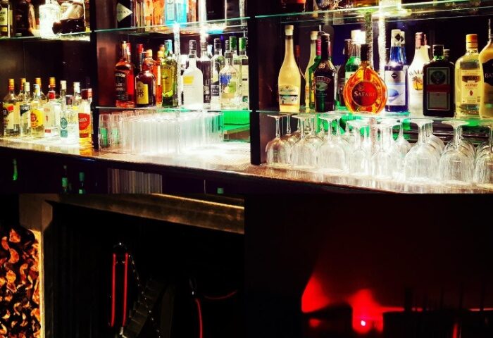 XXL Club Lisbon bar with liquor bottles and glassware. Gay nightlife in Lisbon, Portugal. Popular gay bar for men's travel advice.