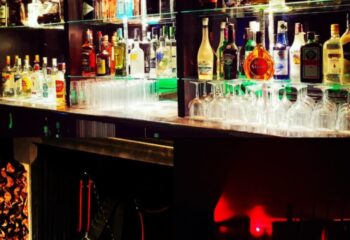 XXL Club Lisbon bar with liquor bottles and glassware. Gay nightlife in Lisbon, Portugal. Popular gay bar for men's travel advice.