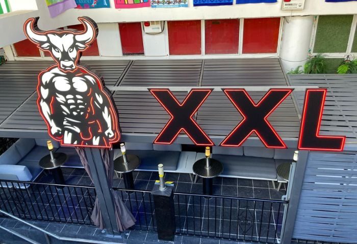 XXL Gay Cruise Club in Torremolinos. Muscled bull logo and large XXL sign. Gay travel in Spain. Nightlife and gay bars.