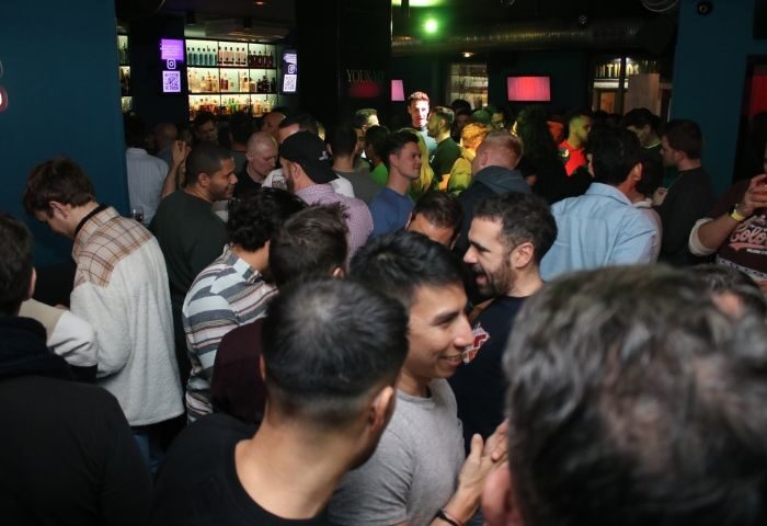 Inside YOUME Gay Bar in Madrid: A crowded scene of gay men socializing, drinking, and enjoying the nightlife. Gay Travel Advice.