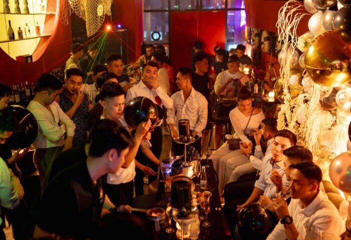 Z9 Bar, Ho Chi Minh City: Gay nightlife scene. Men gather at a bar, some holding drinks, in a lively, festive atmosphere with balloons.