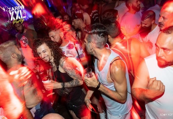 Gay nightlife scene at Zarpa Bear de Copas in Madrid. Men are partying and dancing in the gay bar, enjoying the vibrant atmosphere.