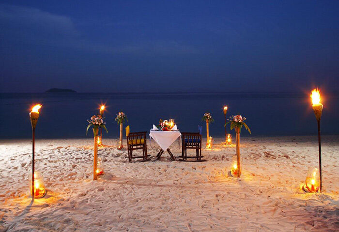 Zeavola Hotel beachfront dining at Phi Phi. Perfect gay honeymoon destination. Romantic table for two lit by tiki torches on the sand.