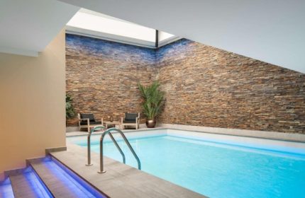 Indoor pool at art'otel Amsterdam, a gay hotel near gay bars and saunas. Relaxing area with chairs and stone wall. Coolest gay hotel.