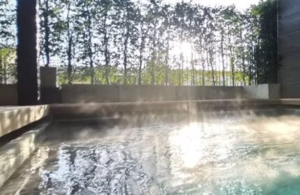 Krubb Bangkok pool view. Steaming water in a pool, sun shining through trees. Gay travel in Bangkok, Thailand. Relaxing vacation.