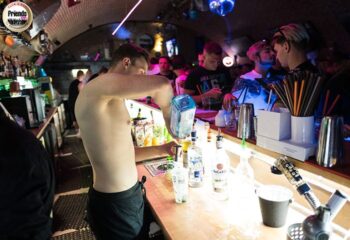 Friends Prague: Shirtless bartender mixes drinks at a busy gay bar. Prague's nightlife scene. Gay travel advice. friends-prague.jpg