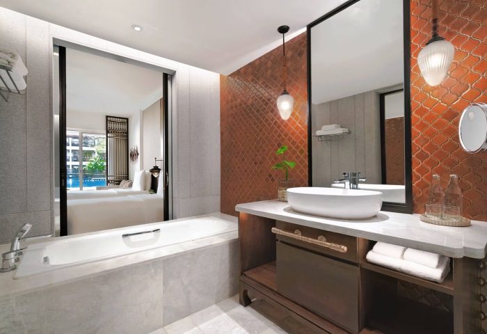 JW Marriott Khao Lak Resort & Spa deluxe bathroom. Bathtub, sink, and mirror. Luxury hotel bathroom interior. Gay travel advice.