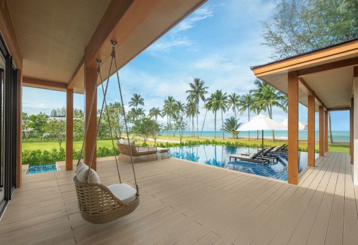 JW Marriott Khao Lak Resort villa terrace with swing, pool, and ocean view. Classic horizontal shot of gay travel destination.