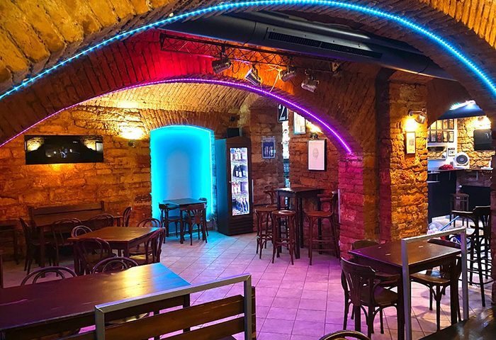 Klub 21 Prague interior. Gay bar with brick arches, neon lighting, tables, and bar stools. Prague gay travel advice.