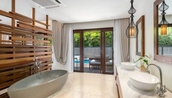 SAii Koh Samui Villa's bathroom. Modern design with soaking tub, double sinks, and outdoor access. Luxury gay travel accommodation.