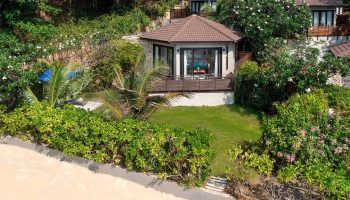 SAii Koh Samui Villas: Room 008933. Tropical villa with a brown roof, surrounded by lush greenery. Perfect for gay men's travel and relaxation.