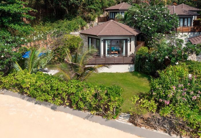 SAii Koh Samui Villas: Room 008933. Tropical villa with a brown roof, surrounded by lush greenery. Perfect for gay men's travel and relaxation.