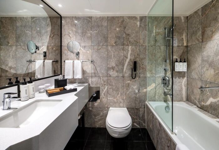 voco Orchard Singapore Hotel bathroom. Modern design with marble tiles, sleek fixtures. Near gay bars, shopping mall. Top gay hotels.