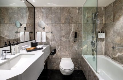 voco Orchard Singapore Hotel bathroom. Modern design with marble tiles, sleek fixtures. Near gay bars, shopping mall. Top gay hotels.