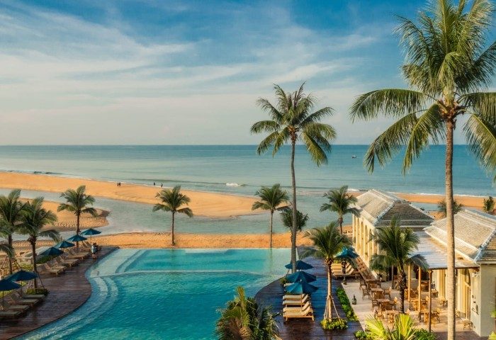 Devasom Khao Lak Beach Resort & Villas aerial view. Pool, palm trees, and beach create a serene tropical paradise. Perfect for gay travel.